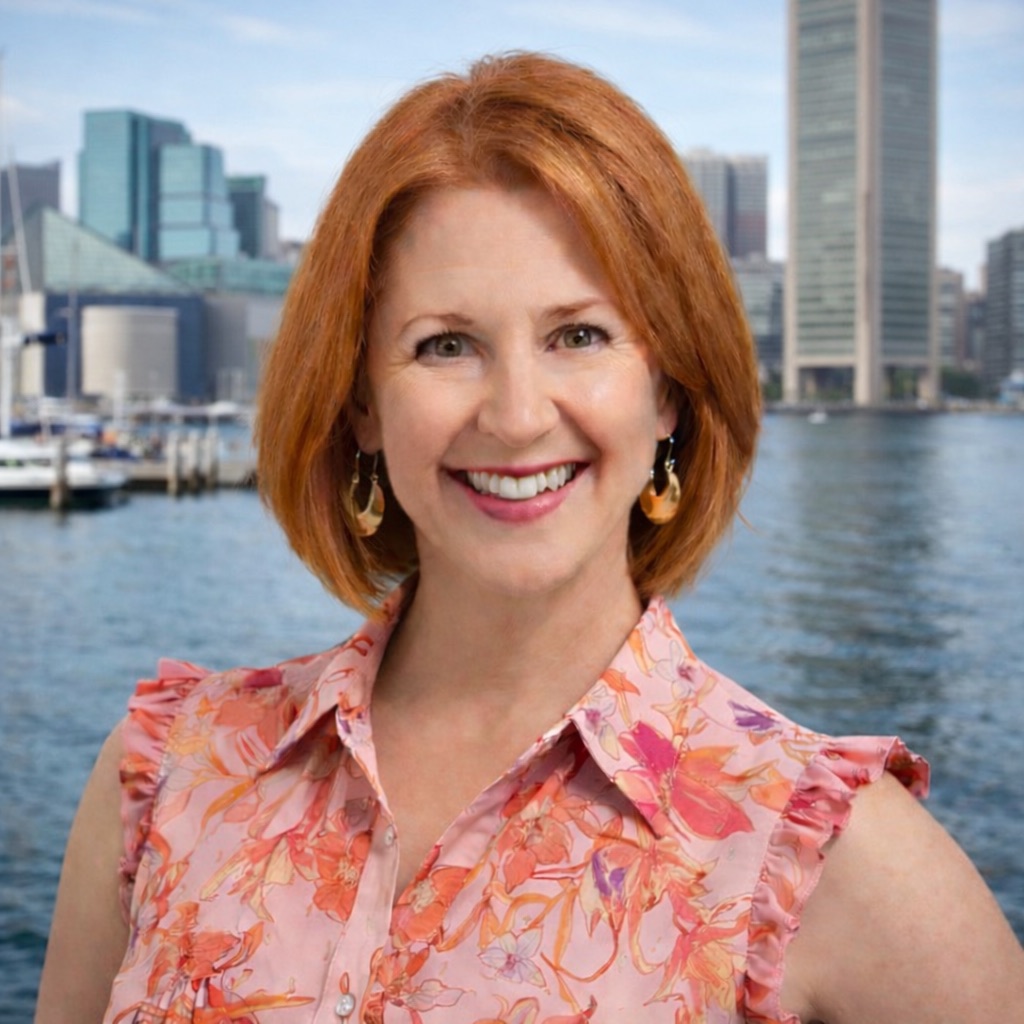 Cathy Becker smiling, with a city harbor skyline behind her